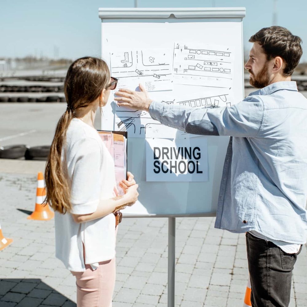 instructor-showing-traffic-shemes-to-a-female-student-outdooors.jpg
