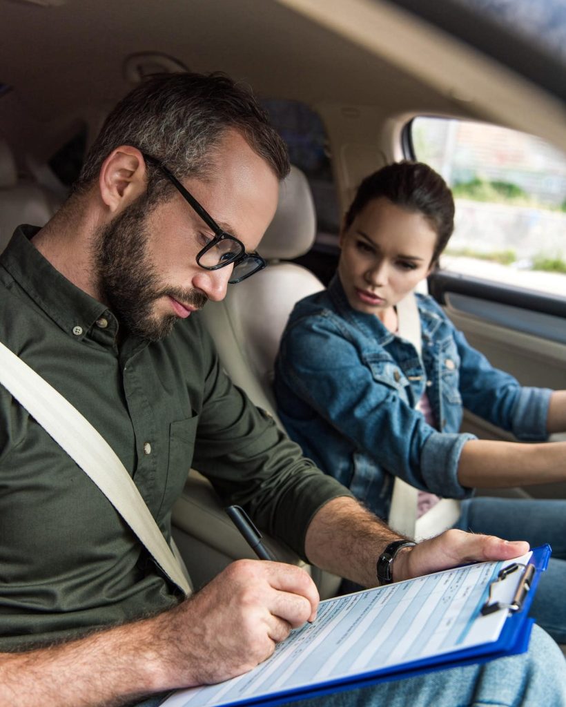 teacher-writing-something-to-clipboard-during-driving-test-1.jpg
